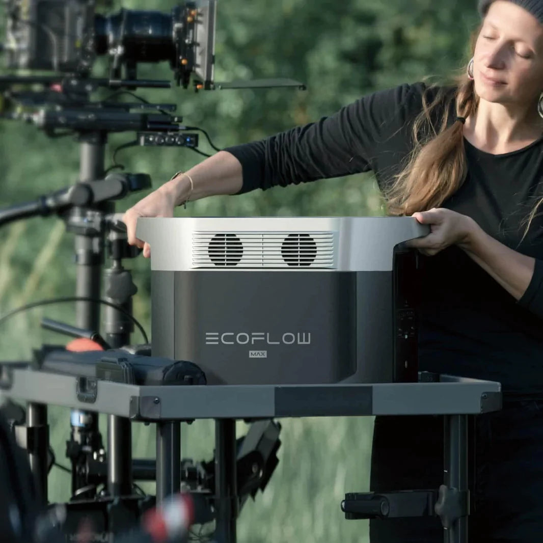 Person setting up EcoFlow DELTA Max 1600 at outdoor filming location with Off-Grid Distribution power solutions.