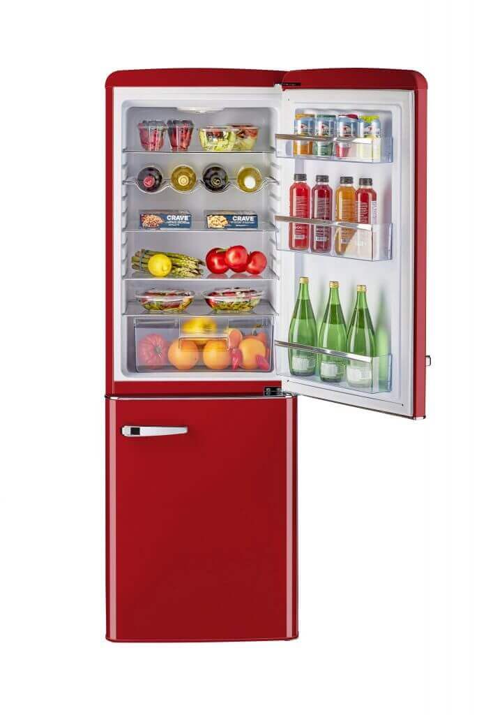 Retro red bottom mount refrigerator with open door showing colorful beverages, fruits, and cans inside.