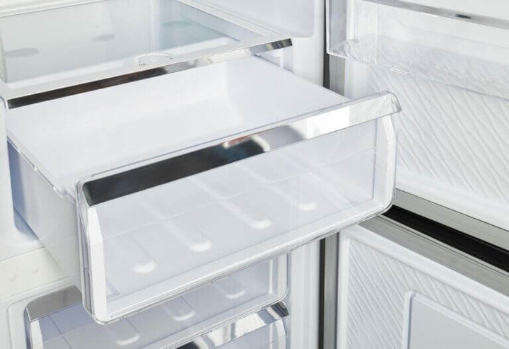 Open drawer inside Unique Prestige electric bottom-mount refrigerator showing modern design and ample storage space.