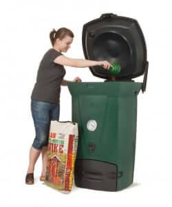 Woman using Biolan 220 ECO Composter from Cabin Depot for efficient year-round kitchen and toilet waste composting.