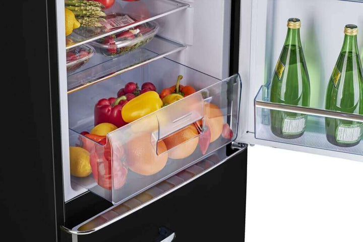 Retro refrigerator interior with fruits and beverages on shelves, showcasing storage capacity and organization.