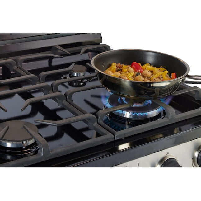 Cooking on a 30” stainless steel propane range with battery ignition and cast-iron grates, featuring sautéed vegetables in a skillet.