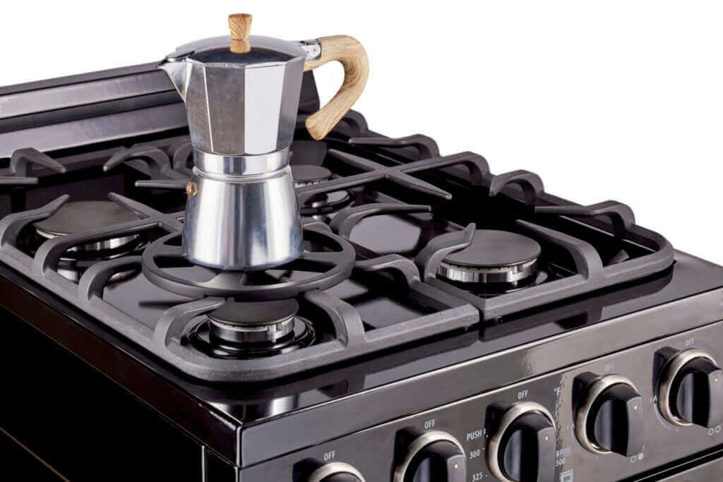 Unique Mini Pot Holder securing small kettle on Classic range stovetop, preventing tipping and ensuring stability for smaller cookware.